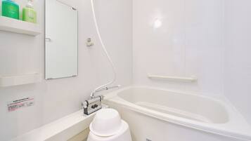 A modern bathroom with a bathtub, a shower, and a toilet. There are two bottles of lotion on a shelf.