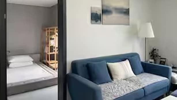 A room with a blue sofa, a bed, a wall-mounted artwork, and a lamp. - River & Hill view Room (Ansan-si)