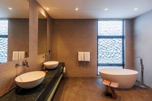 Un bagno moderno con due lavandini, una vasca da bagno ampia e una cabina doccia.