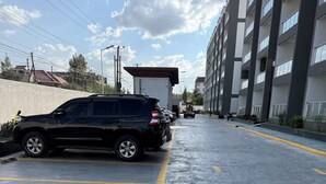 A parking lot with a black SUV parked on the left.