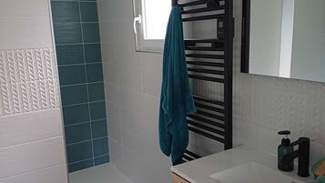 Ducha, bañera de hidromasaje, toallas y jabón
