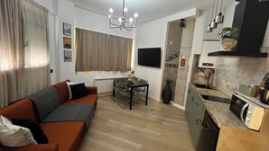 A compact living space with a sofa, dining table, and kitchenette. - La Arquita, tu apartamento en Valladolid (Valladolid)
