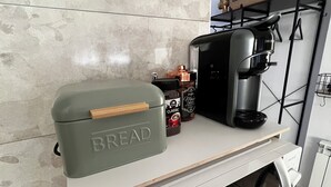 A kitchen counter with a bread box, a coffee maker, and a jar of spices. - La Arquita, tu apartamento en Valladolid (Valladolid)