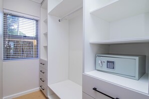 Ein Zimmer mit Fenster, einem Safe und Schubladen.