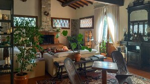 A cozy living room with a fireplace, comfortable seating, and various decorative items. - 4 bedroom awesome home in Quiesa (Quiesa)