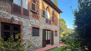 A stone building with multiple windows and shutters, surrounded by greenery. - 4 bedroom awesome home in Quiesa (Quiesa)