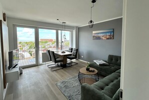 A modern living room with a balcony, a dining area, and a sofa.