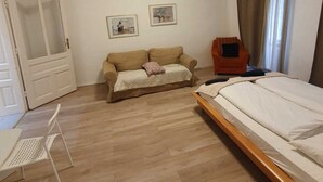 A bedroom with a bed, a sofa, a chair, and a desk. - Modern 2BR Apt Near Karlsplatz (Vienna)