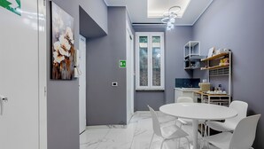A modern kitchen with white cabinets, a white countertop, and a window with a view. - Vatican Gold Medals (Roma)