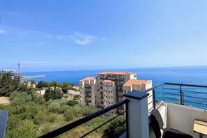 Un balcon avec vue sur la mer et les bâtiments.
