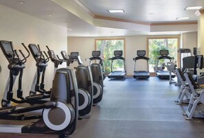 A gym with multiple treadmills, elliptical machines, and stationary bikes.