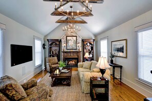 A spacious living room with a fireplace, comfortable seating, and a large flat-screen TV.