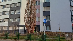 Ein mehrstöckiges Wohngebäude mit Balkonen, einem Fahrradstellplatz und einem Fußweg.
