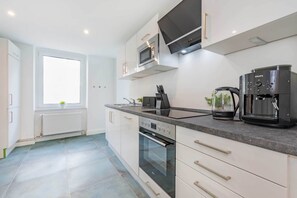 Eine moderne Küche mit eingebautem Backofen, Mikrowelle und Kaffeemaschine.