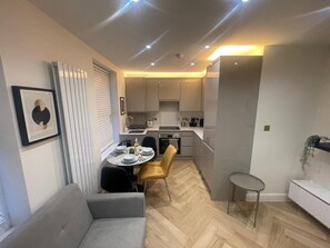 Een moderne keuken met een eethoek, een bank en een klein tafeltje.
