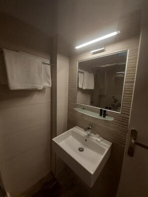 Douche, douche à « effet pluie », sèche-cheveux, serviettes fournies