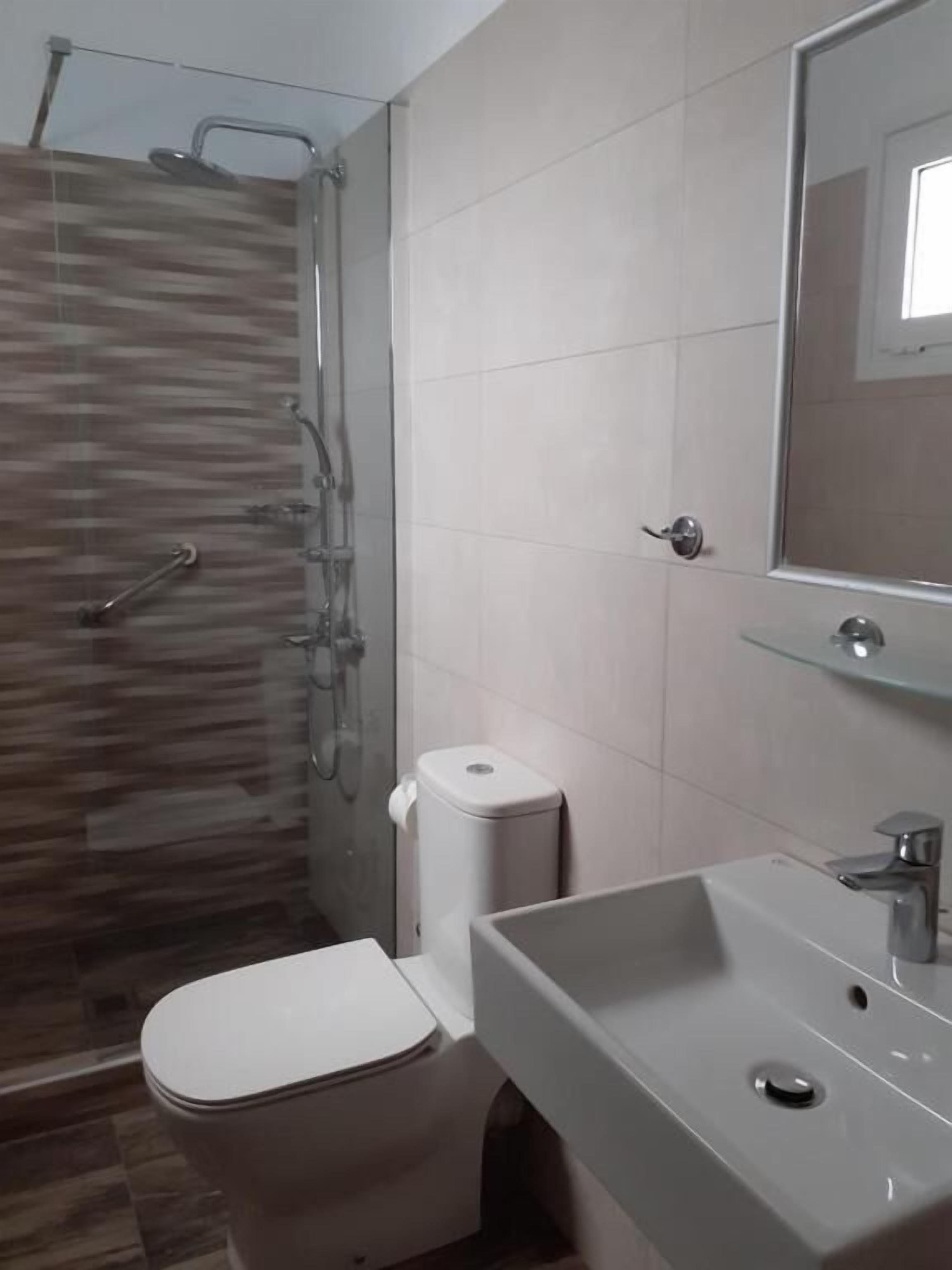 Un baño con ducha, inodoro y lavamanos.