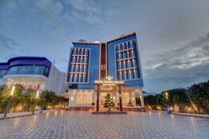 A hotel entrance with a modern design, featuring a prominent sign for Hotel Warm Palace. - Hotel Warma Palace (Yeola)