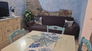 Un comedor con una mesa, sillas, un sofá y un televisor.