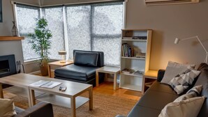A modern living room with a sofa, coffee table, and bookshelf.