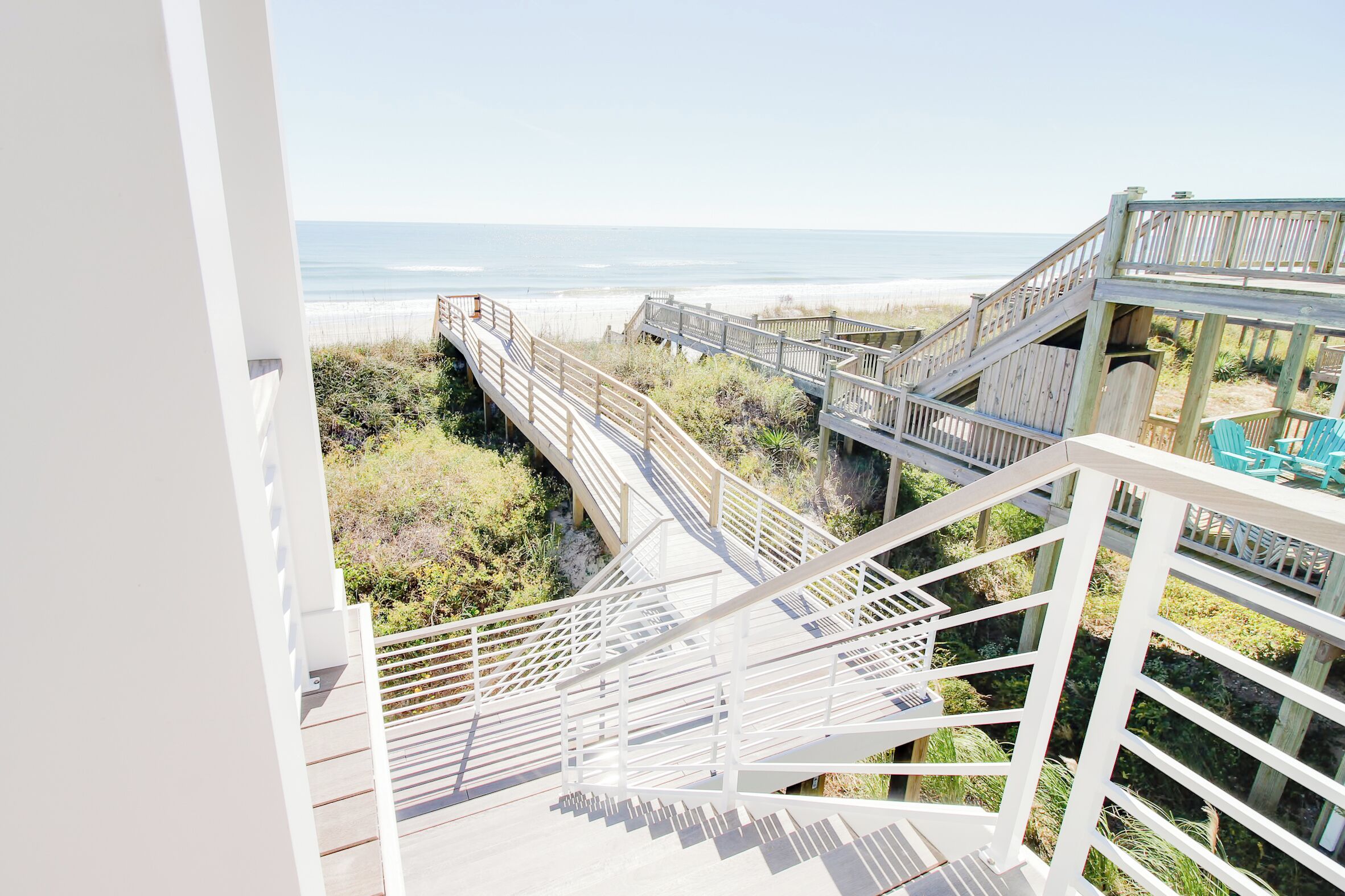 A wooden staircase leading to a beach view.