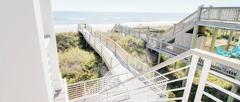 A wooden staircase leading to a beach view.