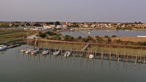 A marina with boats docked, a small town in the background, and a clear sky. - Vendée farmhouse near beach and town center (L'Aiguillon-la-Presqu'île)