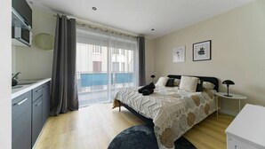 A bedroom with a bed, bedside tables, a desk, and a window with curtains.