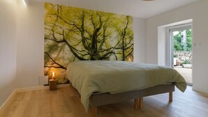Een moderne slaapkamer met een bed, een wandventilator en een groot raam.