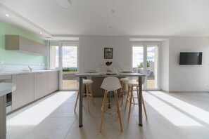 A modern kitchen with a central island, bar stools, and a dining table. - Le Grand Penaud - Large air-conditioned designer duplex apartment (Saulcet)