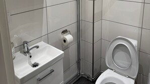 A modern bathroom with a glass shower enclosure, a white sink with a mirror, and a toilet. - Apartment 17 in Sollentuna (Sollentuna)