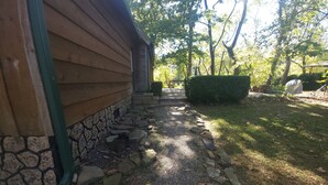 Un sendero de piedra que conduce a una casa de madera con base de piedra.