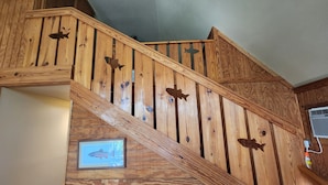 Una escalera de madera con adornos de peces y un cuadro de peces en la pared.