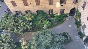 An aerial view of a courtyard with a central fountain, surrounded by lush greenery and a building with multiple windows and shutters. - Enjoy Rhome, your apartment just steps from the Basilica of Santa M. Maggiore (Roma)