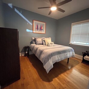 A bedroom with a bed, a ceiling fan, a window with blinds, and a framed picture on the wall. - Charming 2 BR house with pool and hot tub walking distance to the beach/Las Olas (Fort Lauderdale)