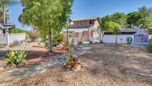 A house with a paved driveway, a fenced yard, and a variety of potted plants. - Lake Elsinore Apt 4 Mi to Water: Pets Welcome! (Lake Elsinore)