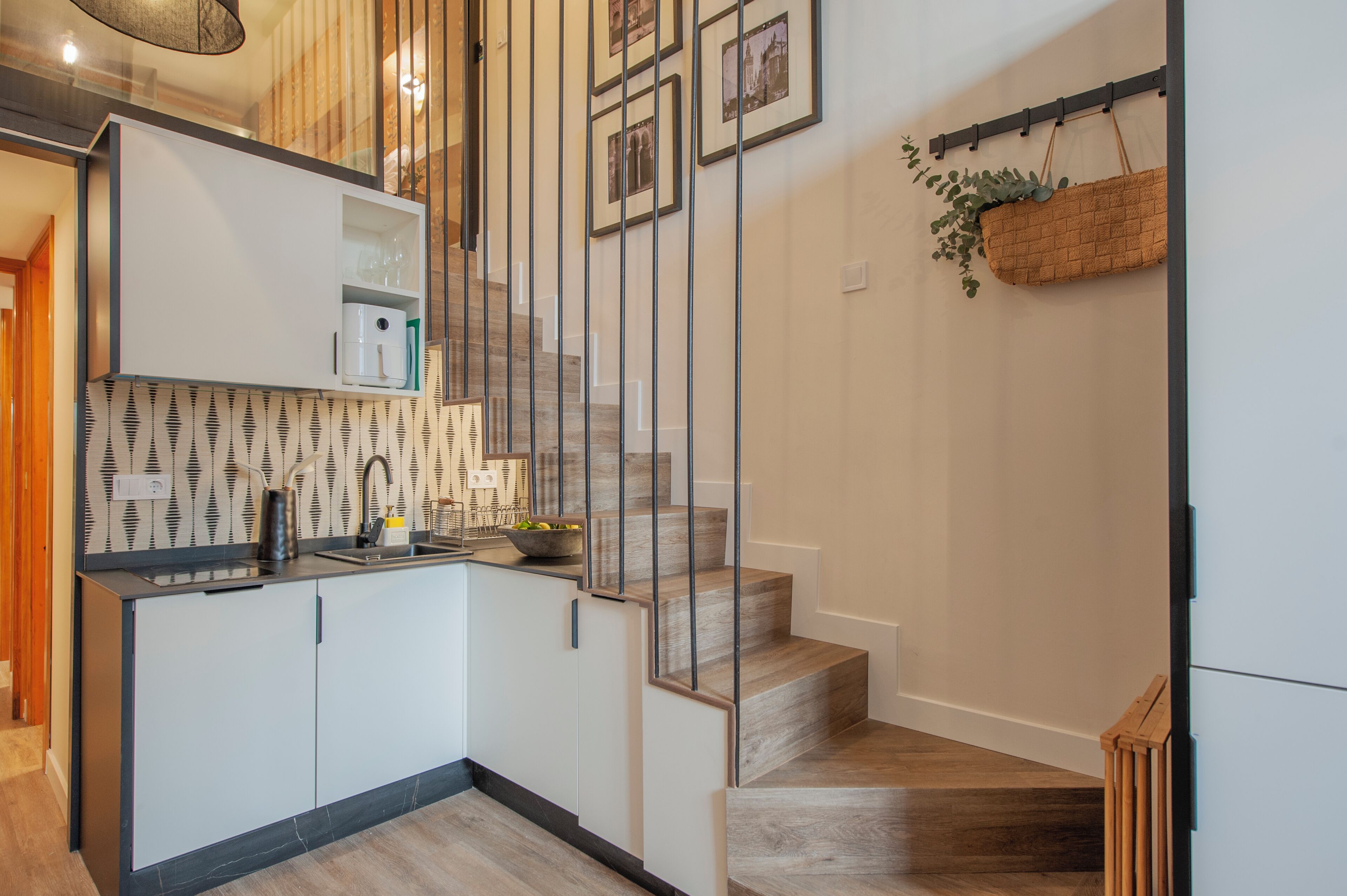 A modern kitchen with a built-in sink, white cabinets, and a patterned backsplash.