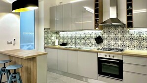 Una cocina moderna con una isla central, electrodomésticos de acero inoxidable y un salpicadero decorativo.