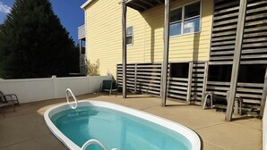 An outdoor swimming pool with a white edge, surrounded by a concrete deck.