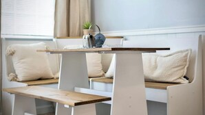Una habitación moderna con un banco de madera y una pequeña mesa con un objeto metálico encima.