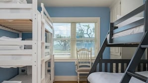 A room with bunk beds, a window with blinds, and a wooden floor. - Island Time 3 Bedroom Home (Rockport)