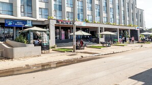 A multi-story hotel with outdoor seating areas and a visible restaurant sign.