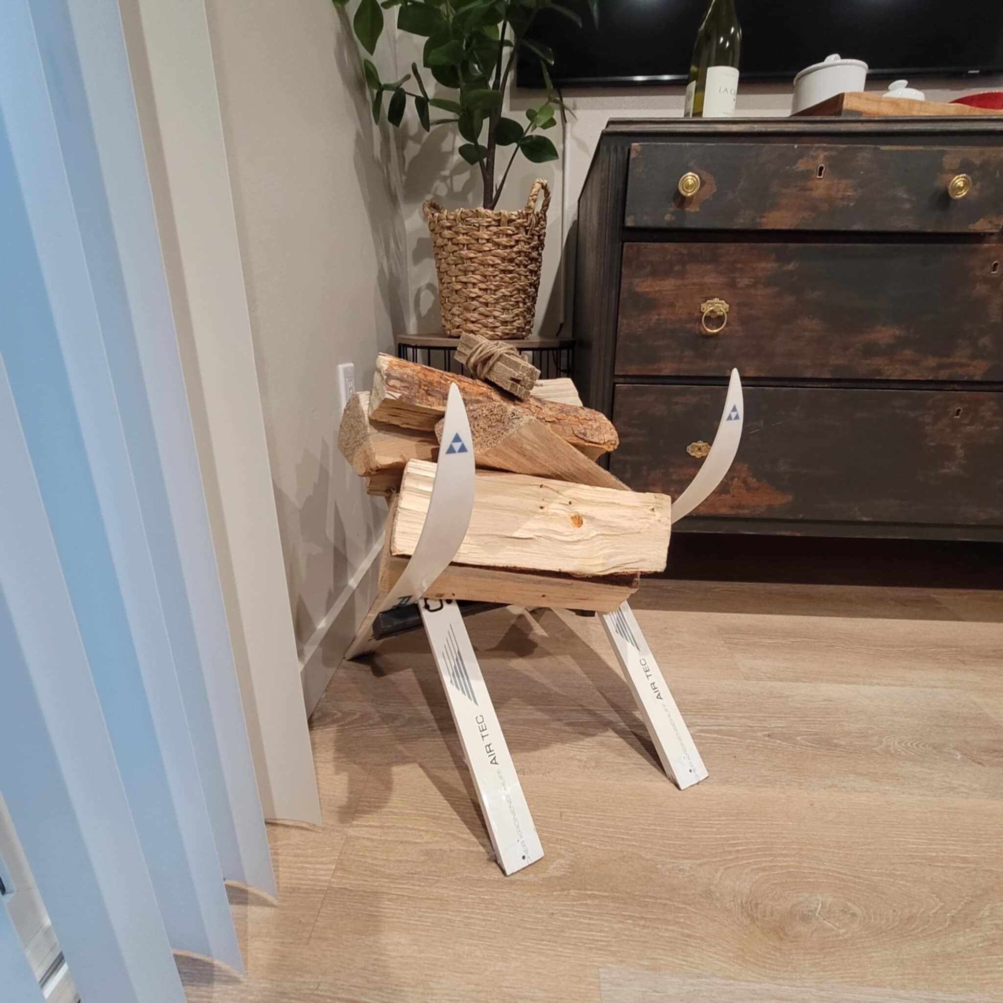 Un angolo di stanza con struttura in legno, un comò in legno scuro e una pianta.