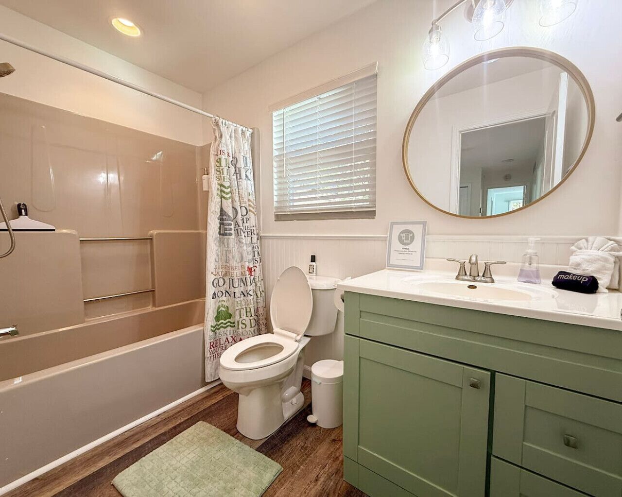 A bathroom with a bathtub, toilet, vanity, and a shower area.