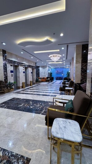 A spacious lobby with a marble floor, seating area, and a reception desk. - Golden Baron Hotel (Makkah)