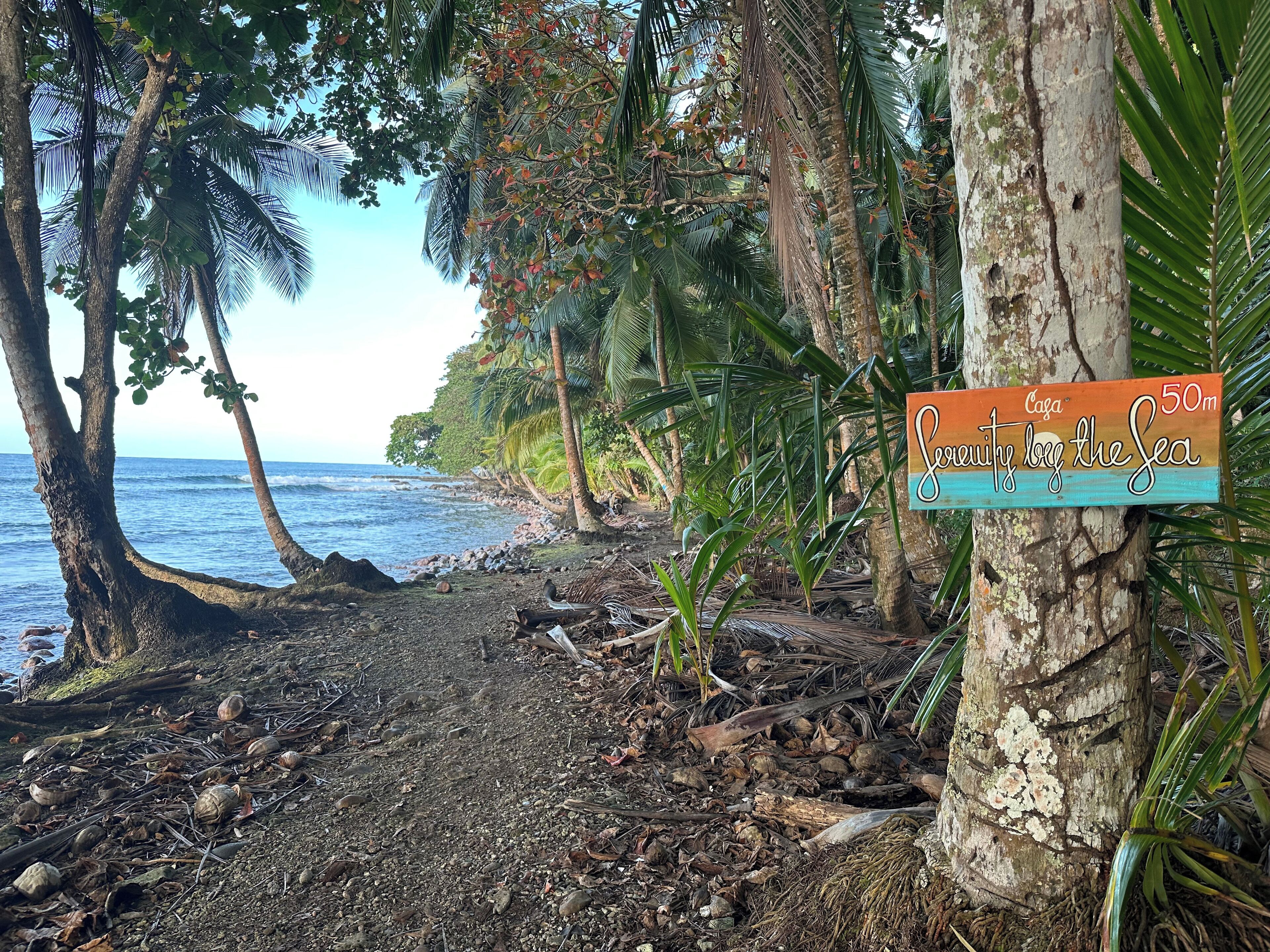 Une plage avec un panneau indiquant « Casa Suite, au bord de la mer », et un indicateur de distance indiquant 50 mètres.
