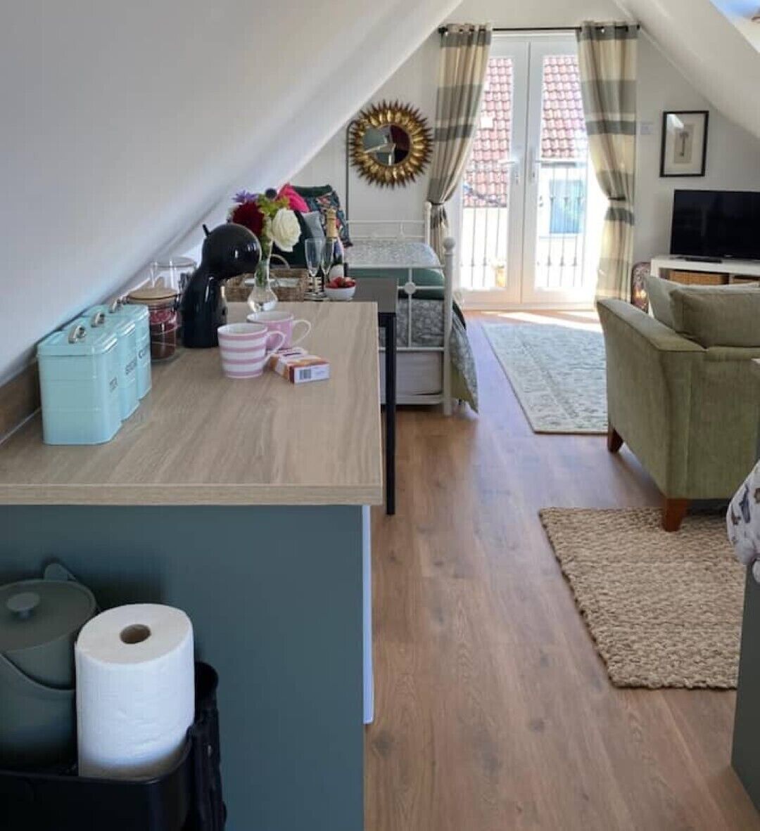 A cozy living space with a kitchen area, a sofa, and a television.