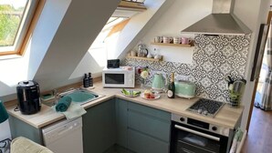 A compact kitchen with a microwave, toaster, and coffee maker. - Grove View Studio Apartment. (Cossington)