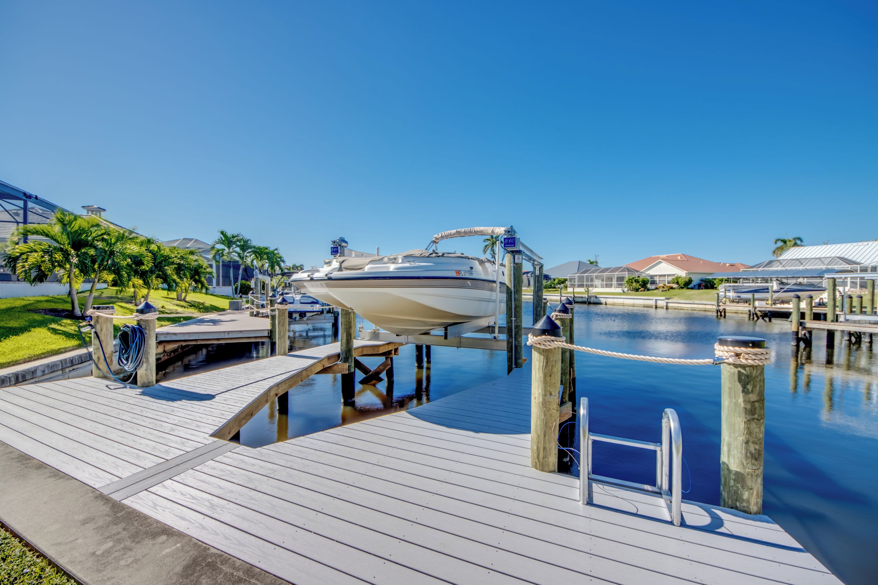 A boat docked at a wooden pier with a clear blue sky.