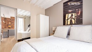A hotel room with a bed, a wardrobe, a mirror, and a poster on the wall. - Chic apartment in the heart of Montmartre Parisian charm & central calm (Paris)